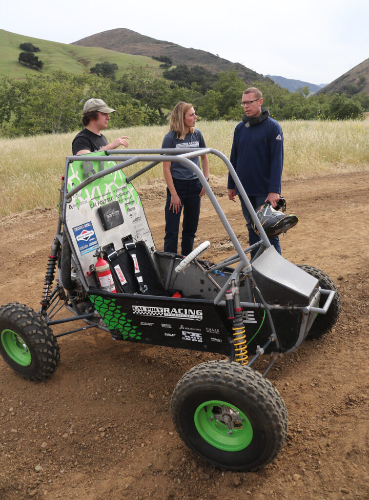 Orfalea College of Business Dean Damon Fleming, far right, gets driving instructions from Joshua Wright and Stassa Cappos from the Cal Poly Racing team.