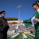 Dean Damon Fleming congratulates a grad during the Orfalea College of Business graduation commencement June 12.