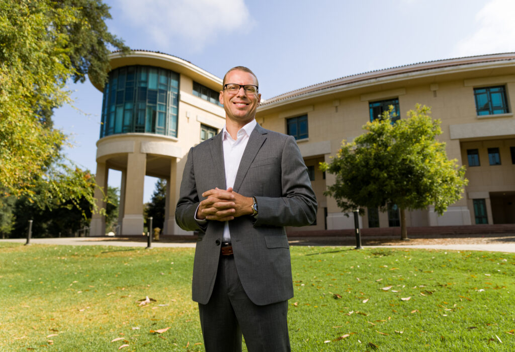Dean Dr. Damon M. Fleming standing on the lawn in front of the Orfalea building.