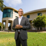 Dean Dr. Damon M. Fleming standing on the lawn in front of the Orfalea building.