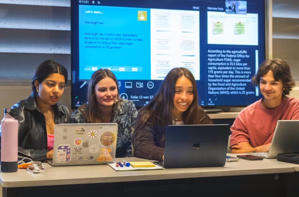 Students use laptops for an assignment in a marketing class