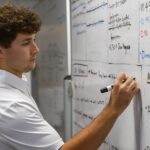 A student writes on a white board