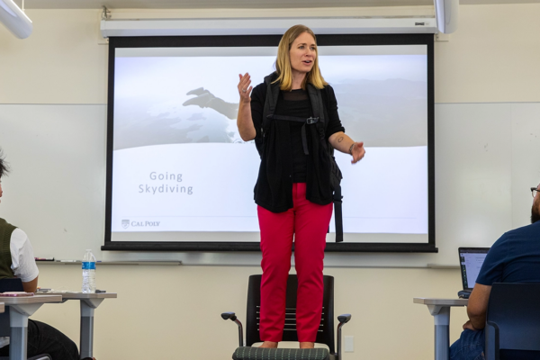 Kim Westermann stands on a chair in class to give her "skydiving" scenario