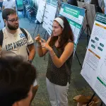 A student discuss her research project during the SURP Symposium