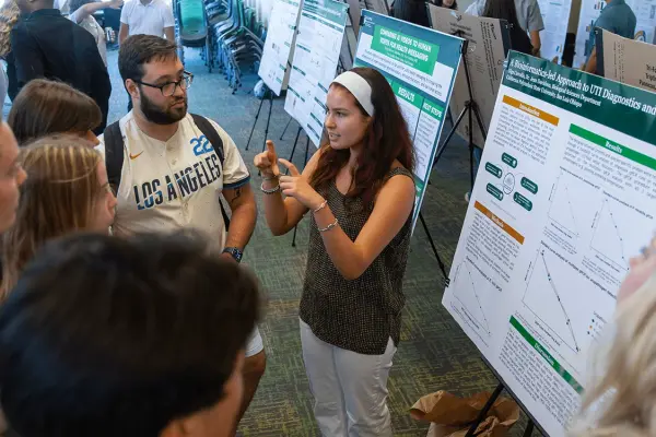 A student discuss her research project during the SURP Symposium